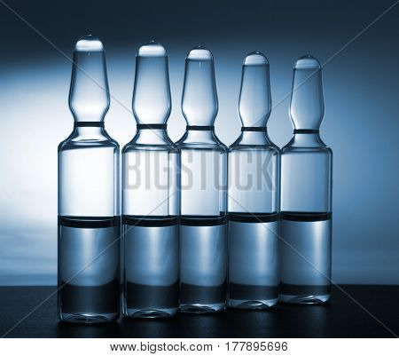 Row of ampulas with medicine on blue background