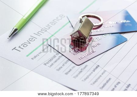 Travel insurance application form with credit cards on white desk background