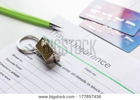 Travel insurance application form with credit cards on white desk background