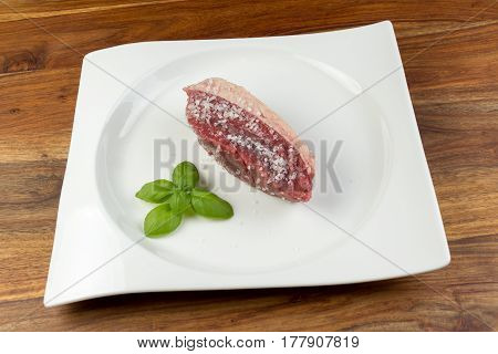 Slice Of Salted Raw Cow Beef (picanha) And Basil Leaves On A White Dish And Vintage Natural Wood Tab