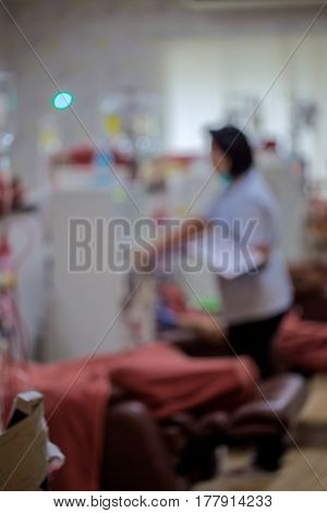 Writing on clipboard with patient in background in hospitalblurred photo