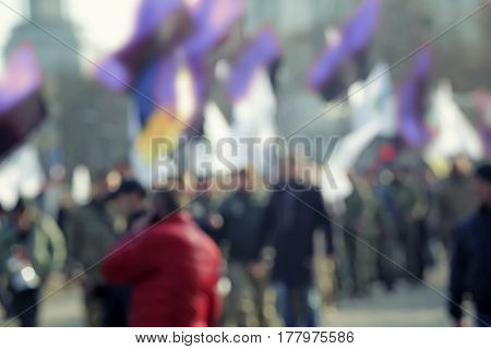 Crowd of people walking on busy city street, blurred view