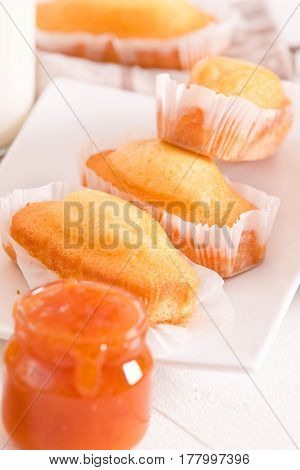 Breakfast with plumcake and apricot jam on white dish.