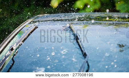 Car Windshield With Rain Drops And Frameless Wiper Blade