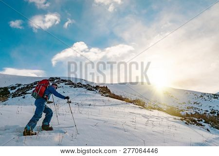A Man In The Mountains. Ski Touring On A Split Snowboard. A Man Stands With His Back To The Viewer A