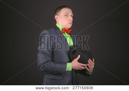 The Chagrined Man With A Bowler Hat Is Hiding His Eyes On A Black Background.
