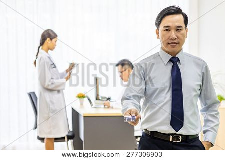 Portrait of Young adult Patient with credit card with examination room medical office background for insurance concept