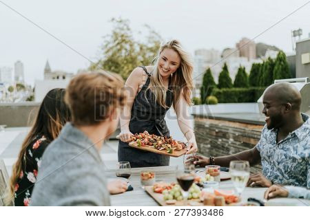 Woman serving vegan barbecue to her friends