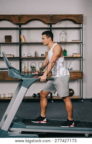 Photo Of Muscular Bi-racial Sportsman Walking On Treadmill