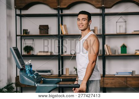 Cheerful Bi-racial Sportsman Listining Music In Earphones