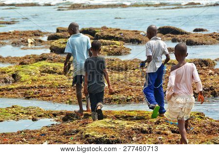 African Children Walk On Ocean Shore. Developing Countries Of Africa. Ghana, Accra - January 29, 201