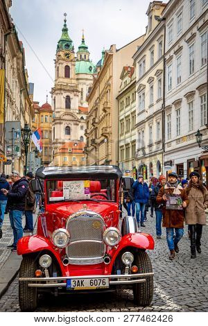 Prague, Czech Republic - 6.01.2019: Red Retro Car And Church Of Saint Nicolas Or Kostel Svateho Miku