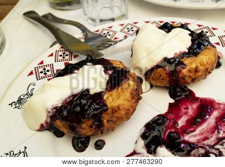 Papanasi, A Traditional Romanian Dessert Of Doughnuts, Cream And Jam