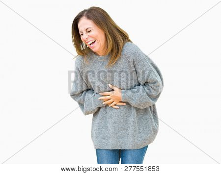 Beautiful middle age woman wearing winter sweater over isolated background Smiling and laughing hard out loud because funny crazy joke. Happy expression.