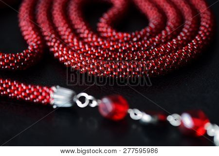 Lariat Necklace Red Color With Bead Decoration On A Dark Background Close Up