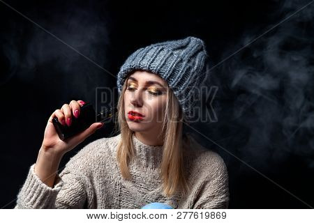 A Blonde In A Knitted Sweater And Hat On A Black Background With Closed Eyes And Professional Make-u