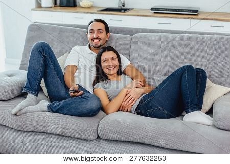 Husband And Wife Sitting On A Sofa