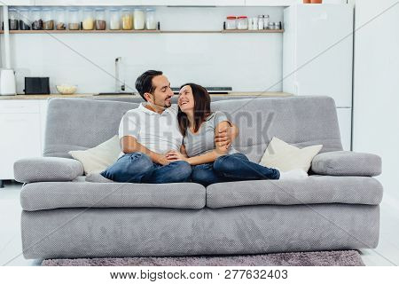 Husband And Wife Sitting On A Sofa
