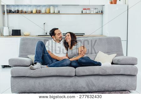 Husband And Wife Sitting On A Sofa