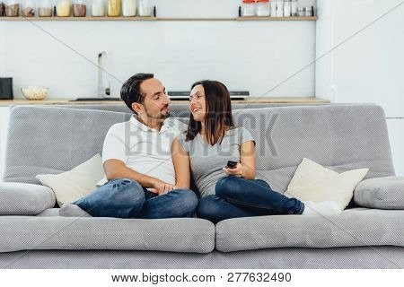 Husband And Wife Sitting On A Sofa