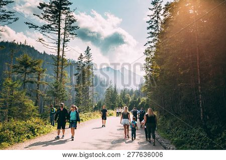 Tatra National Park, Poland - August 29, 2018: Group Of Tourists People Walking On Hiking Trail Thro