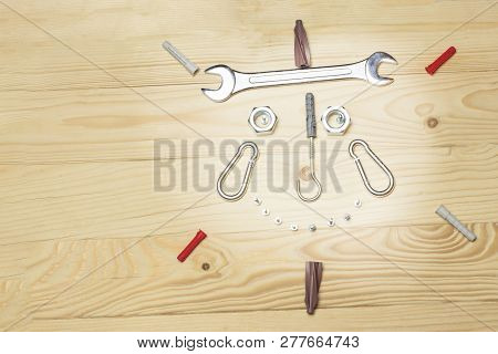 Laid Out A Funny Face Image, From The Bolts And Nuts He Smiles. Top View, On Wooden Background. At A