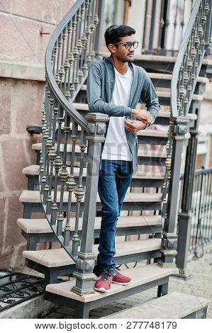 Stylish Indian Man At Glasses Wear Casual Posed Outdoor Against Iron Stairs.