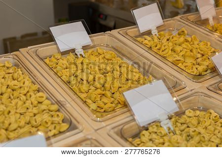 Raw Cappelletti And Tortellini Italian Pasta In Containers For Sale.