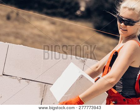 Strong Pretty Woman Working On Construction Site, Building House, Installing Gray Airbricks. Industr