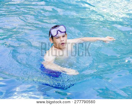 Teenager Boy Wearing Mask Swimming In The Pool. Happy Holiday Concept. Cute Happy Little Boy Swimmin
