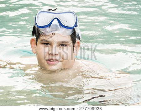 Teenager Boy Wearing Mask Swimming In The Pool. Happy Holiday Concept. Cute Happy Little Boy Swimmin