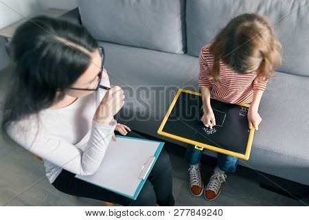 Young Female Psychologist Talking With Patient Child Girl In Office. Mental Health Of Children.