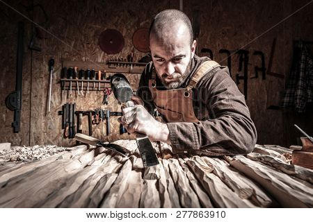 portrait of carpenter at work with hammer and gouge