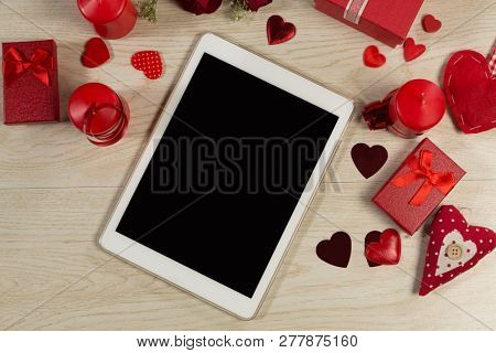 Heart shape decorations, gifts and digital tablet on wooden table