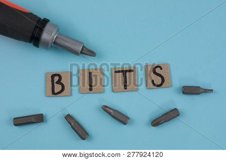 One Manual Screwdriver And Five Bits For Screwdriver Near Handwritten Word Bits On Cardboard Squares