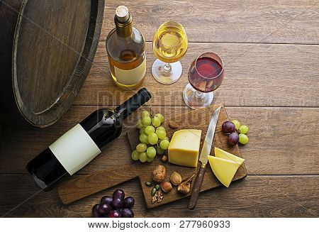 Glasses And Bottles Of Red Wine And White Wine On Wooden Background