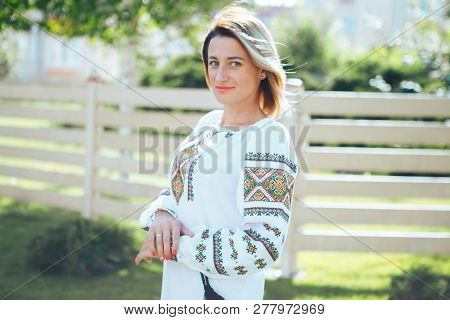Beautiful Young Woman In Traditional Ethnic Ukrainian  Style. Vyshivanka Blue With White Embroidery