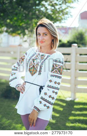 Beautiful Young Woman In Traditional Ethnic Ukrainian  Style. Vyshivanka Blue With White Embroidery