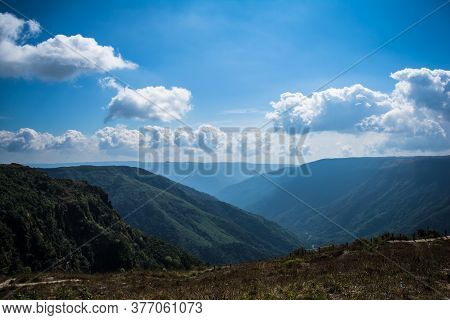 Natural View Of The Folded Mountains And Lush Green Valleys With Clear Sky And Clouds Of Cherrapunji