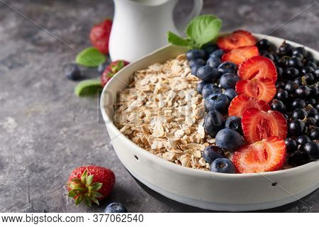 Healthy Breakfast, Muesli With Currants, Blueberries And Strawberries In Bawl On Dark Backgrund