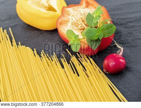 Raw Pasta On The Table With Vegetables, Papryka, Radish And Mint.