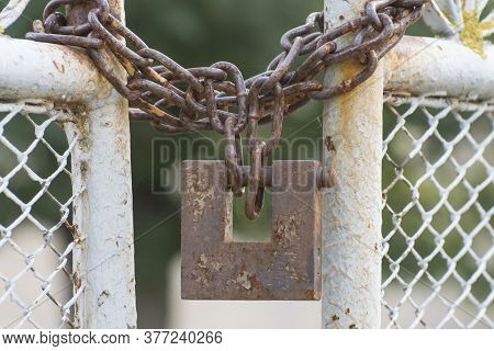 Old Gate Closed On A Padlock. Symbol Of The End Of The Path Or Life Barriers.
