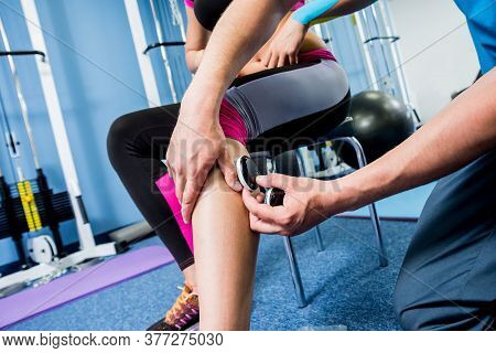 Physical Therapist Install Electrostimulator On The Muscles Of The Legs.