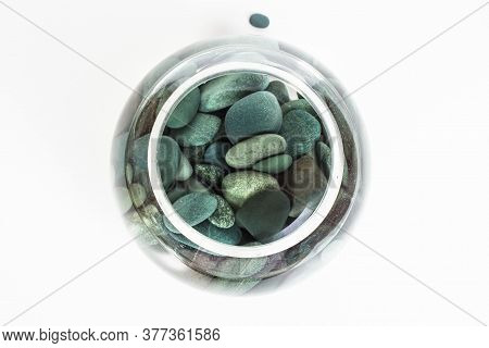 Sea Stones Turquoise In Water In A Glass Vase From Above On A White Background