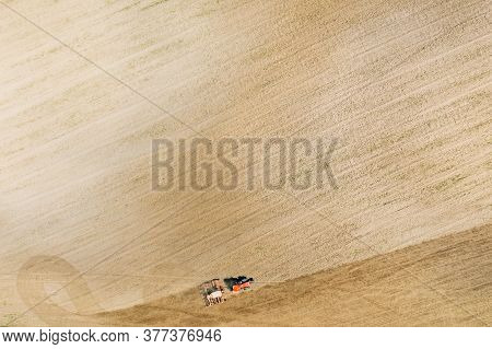 Aerial View. Tractor With Seed Drill Machine Sowing The Seeds For Crops In Spring Season. Beginning 
