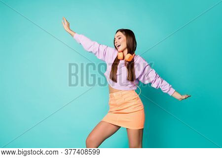 Photo Of Cute Lovely Millennial Lady Listen Modern Technology Earphones Dancing Overjoyed Raise Hand