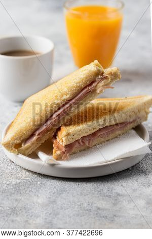 Ham And Cheese Sandwich, Cup Of Coffee With Milk And Orange Juice Glass On Concrete Table In Coffee 