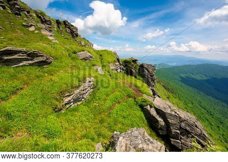 Rock On The Grassy Slope. Sunny Summer Landscape In Mountains. Ridge In The Distance. Clouds On The 
