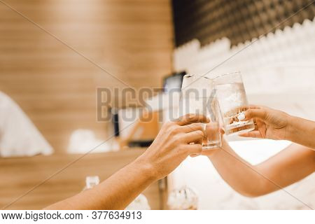 Leisure, Holidays, Eating, People And Food Concept - Friends Having Dinner At Restaurant And Clinkin