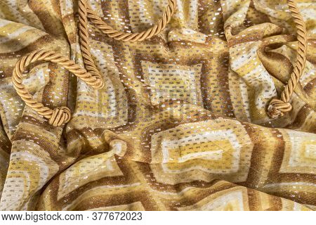 Golden Rope With Knot On A Silk Background.